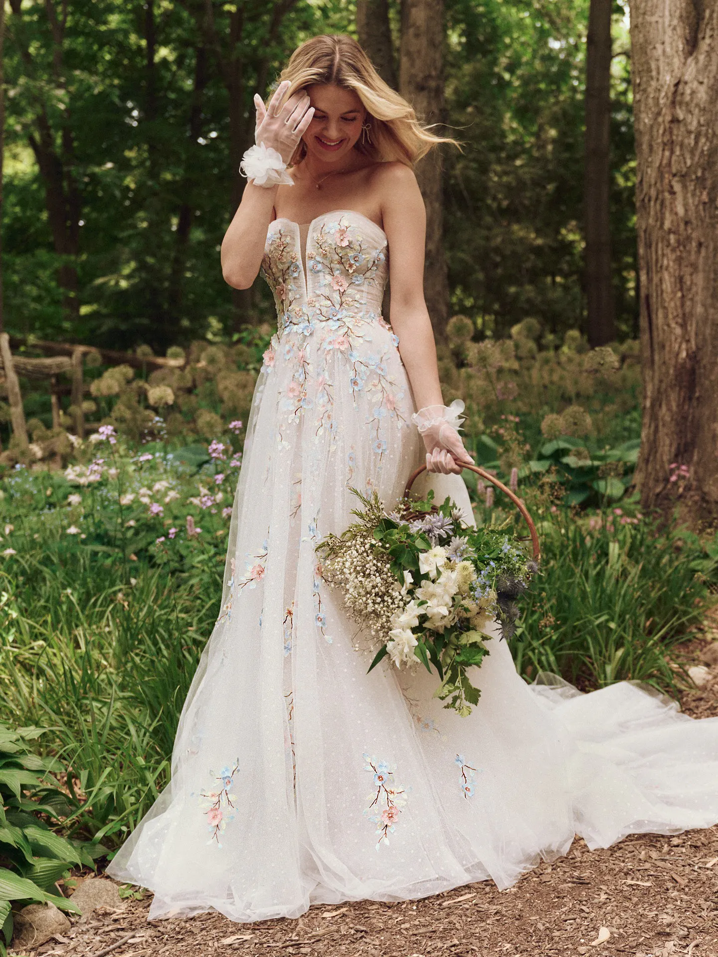 Maggie Sottero Zephyrine front view floral A-line wedding gown in a garden setting