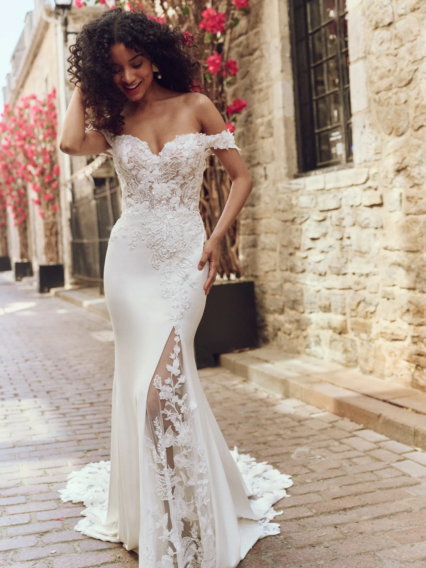 Maggie Sottero Adeline front view lace sheath dress with floral detail in cobblestone alley.