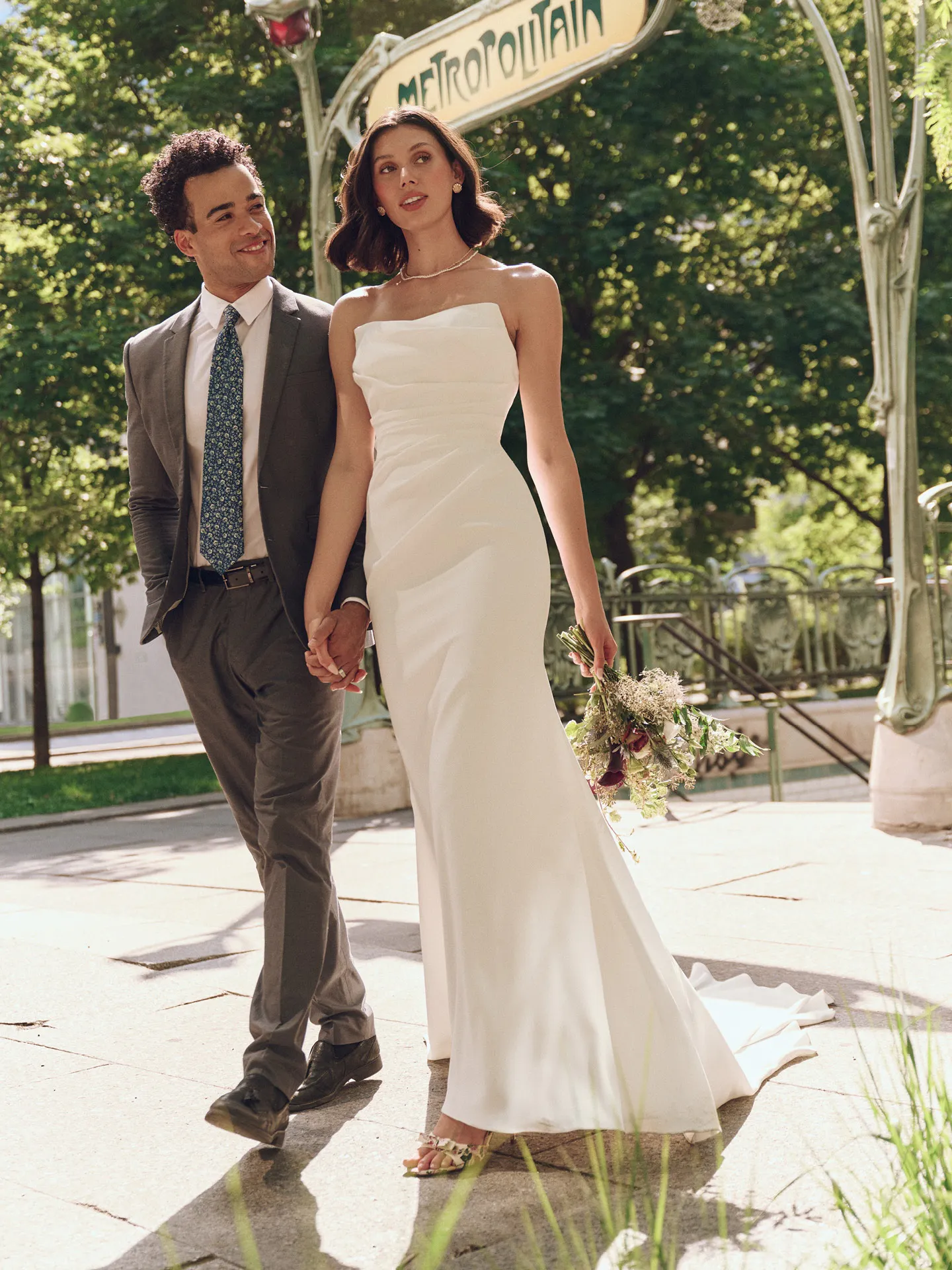 Rebecca Ingram Denise front view, draped crepe gown with cat eye neckline, outdoors.