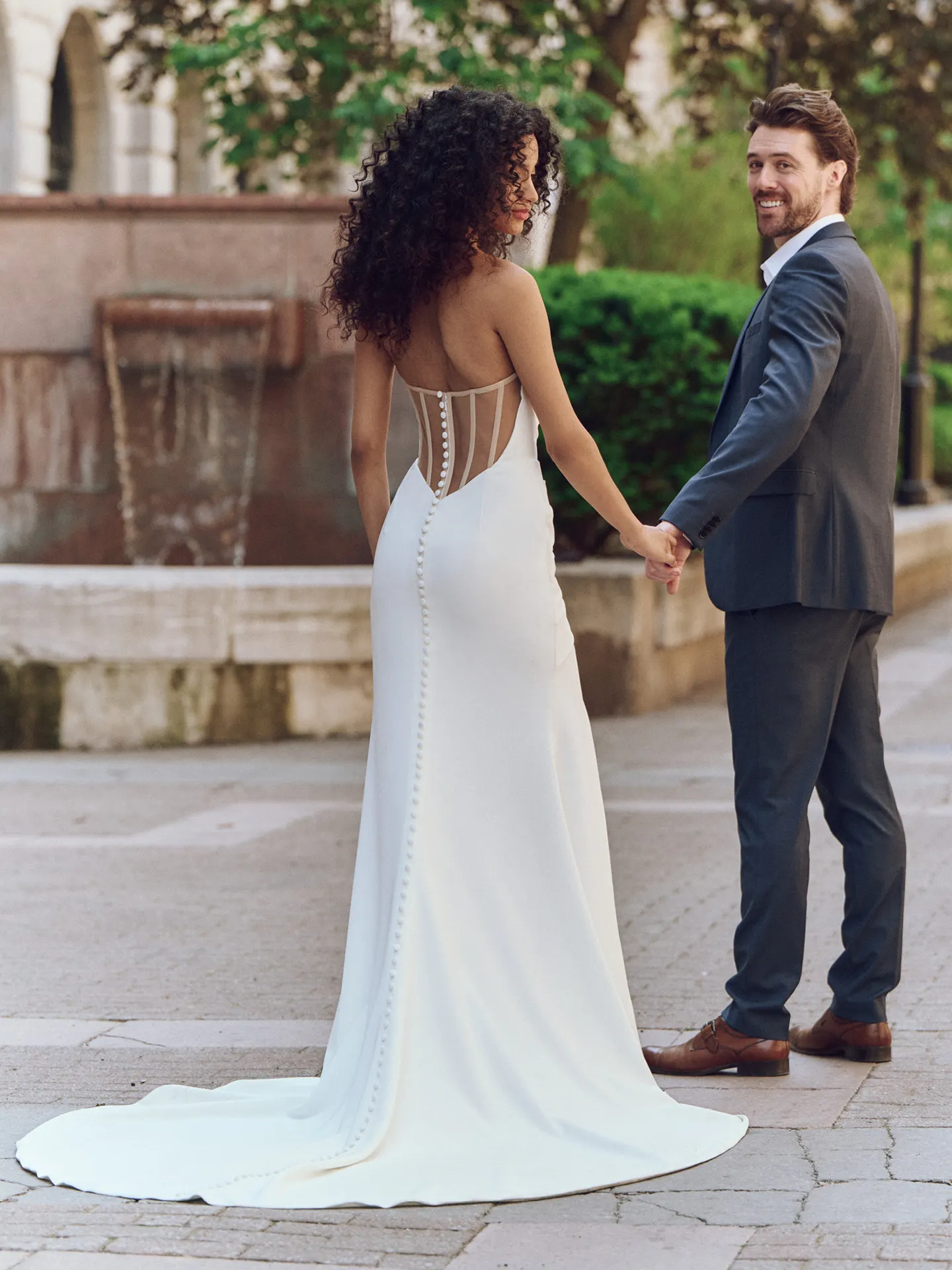 Maggie Sottero Kailani back view, crepe sheath dress with basque waist, buttons down train