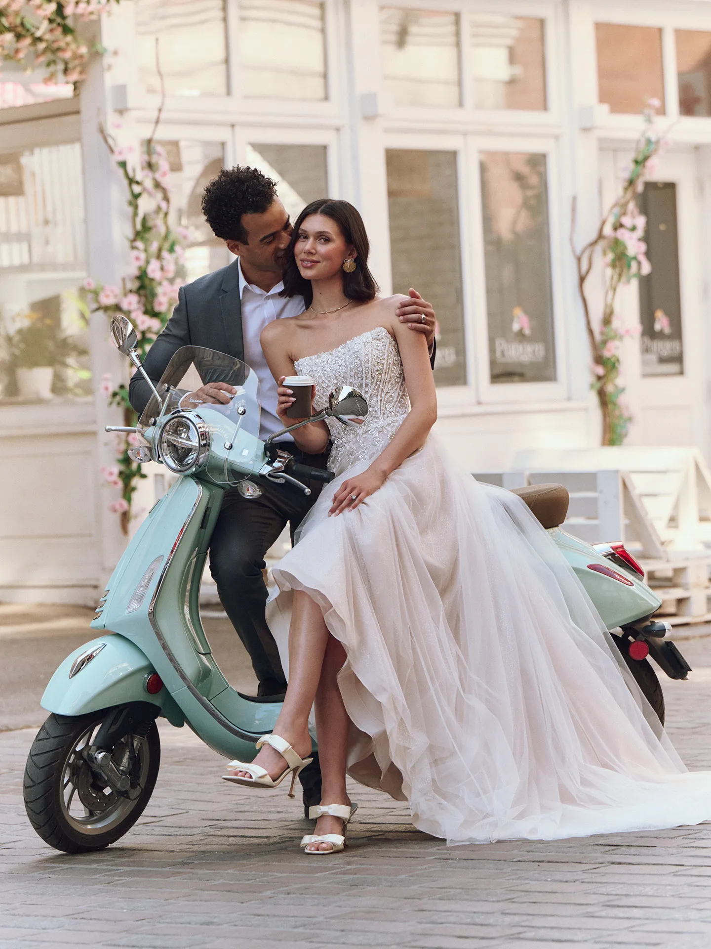 Maggie Sottero Yvette wedding gown in courtyard, seated on mint scooter with coffee.