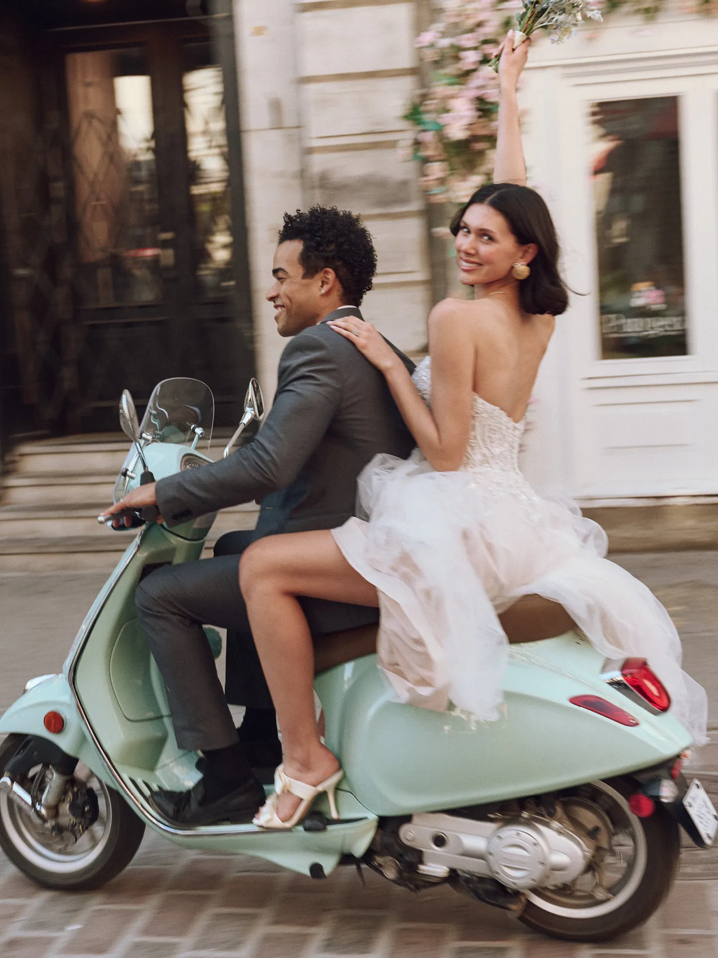 Maggie Sottero Yvette back view riding mint scooter, city street background