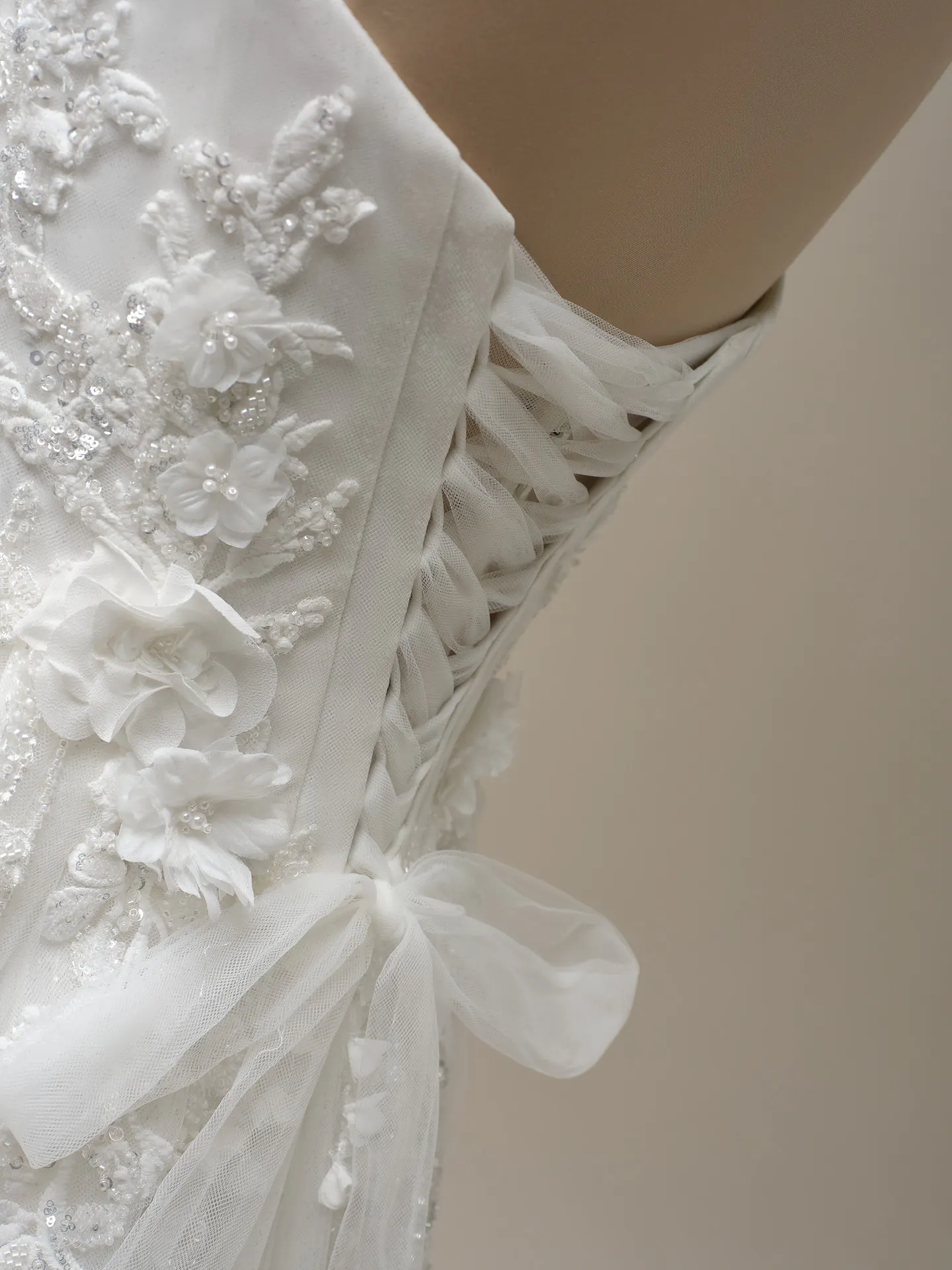 Maggie Sottero Logan side view lace-up beaded A-line dress detail with floral and bow accents
