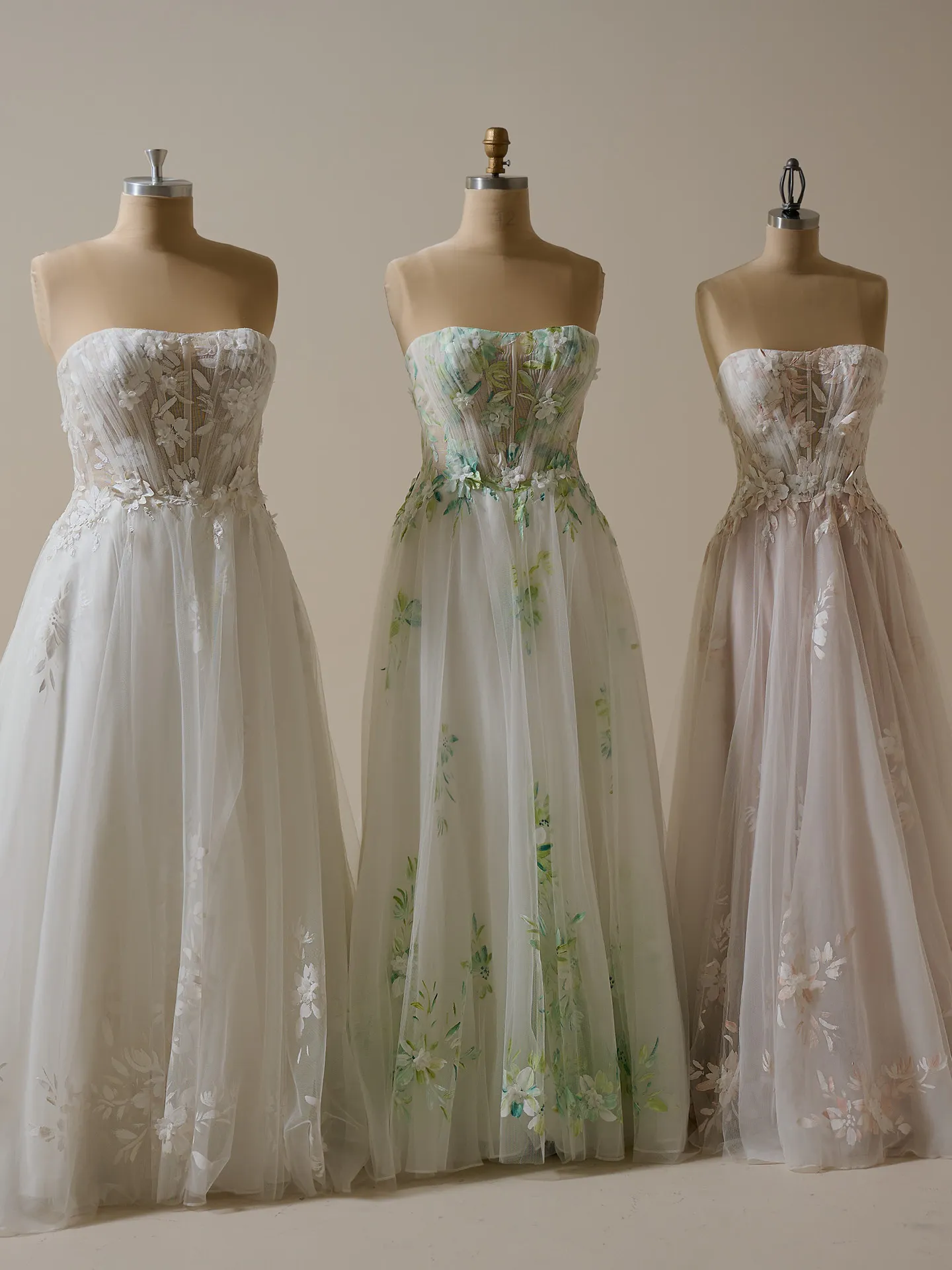 Maggie Sottero Vineyard A-line bridal gowns with floral designs on dress forms.