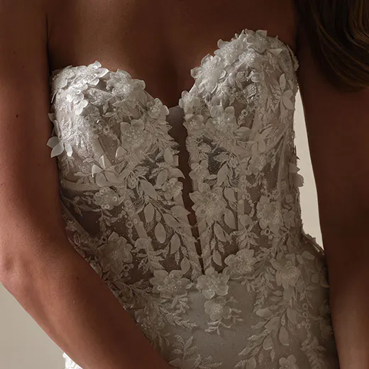 Maggie Sottero Roberta lace fit-and-flare dress, front view with exposed boning and floral details.