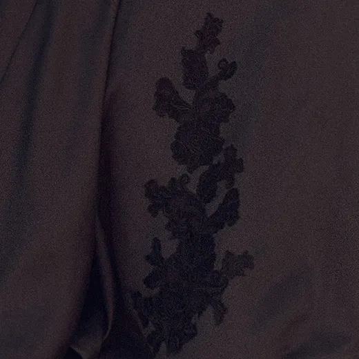 Maggie Sottero Serafina detail black floral embroidery on satin fabric.