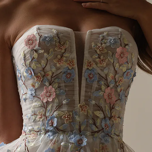 Zephyrine floral A-line gown close-up with colorful embroidered flowers.