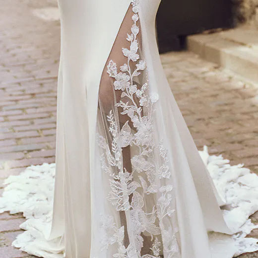 Maggie Sottero Adeline sheath dress with lace detail on cobblestone path.