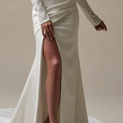Maggie Sottero Kailani side view, crepe wedding dress with leg slit and long sleeves.