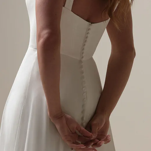 Rebecca Ingram Olivianna back view simple buttoned crepe A-line bridal dress