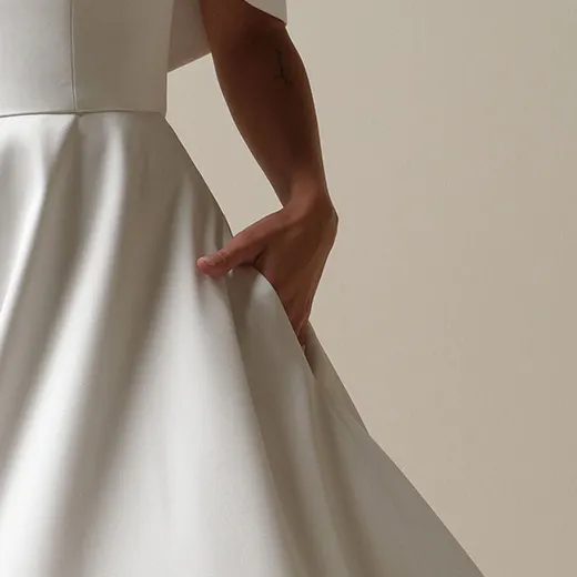 Maggie Sottero Perri A-line dress with banded cuff detail, fabric glimmering in the light