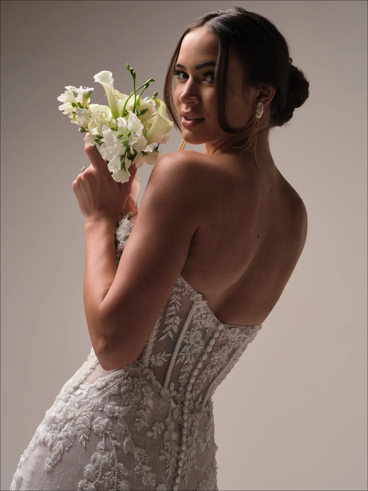 Benjie Royale back view beaded mermaid dress with floral lace, model holding white bouquet