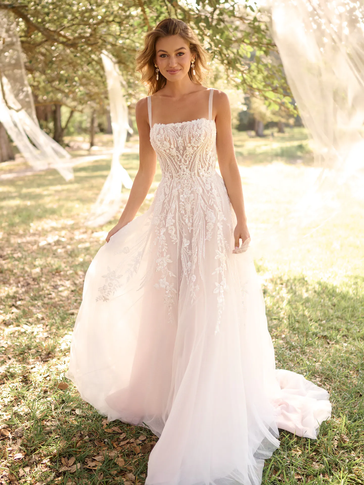 Rebecca Ingram Angie front view shows beaded A-line wedding gown in outdoor setting
