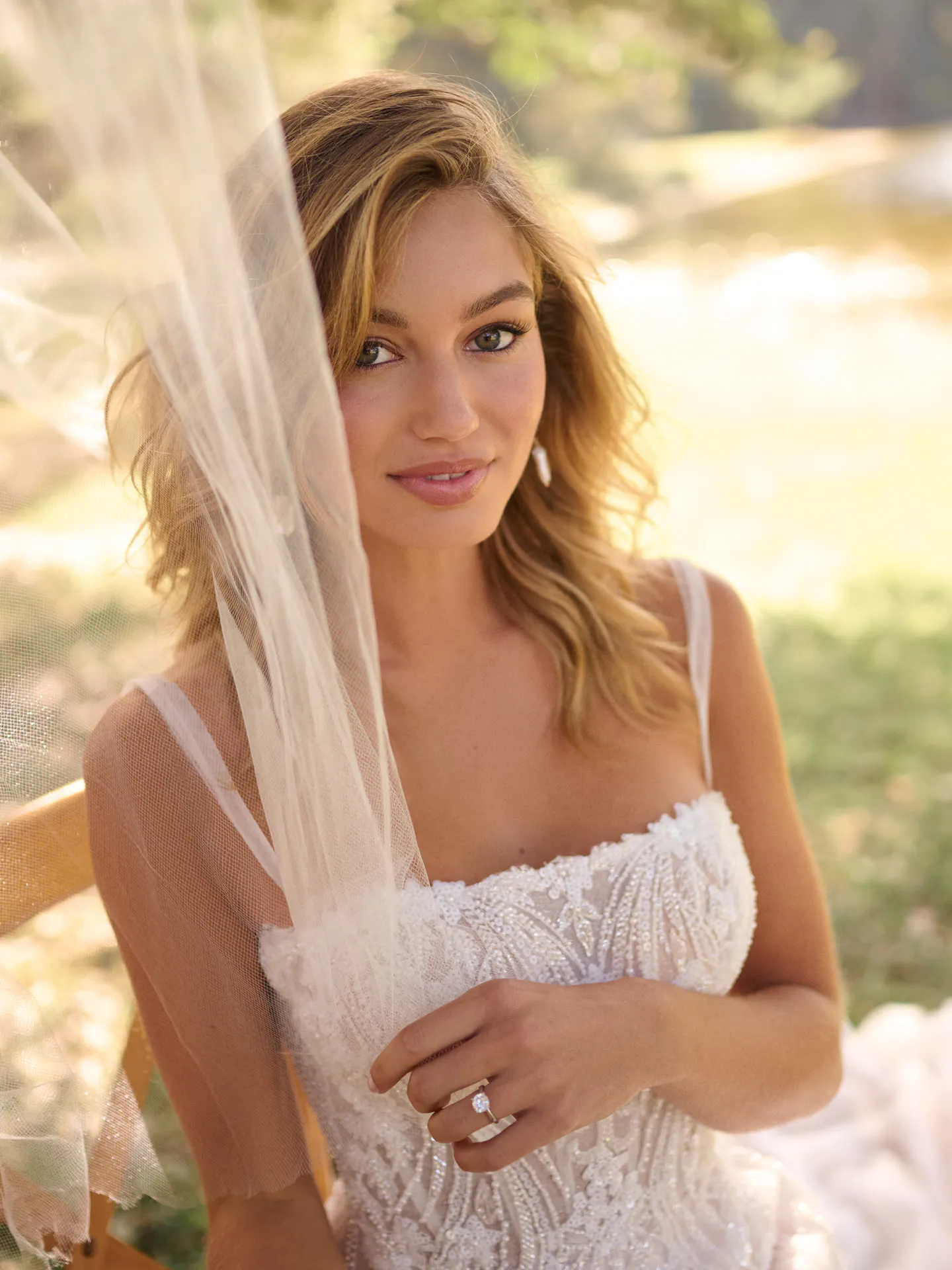Rebecca Ingram Angie front view, beaded A-line gown, holding veil