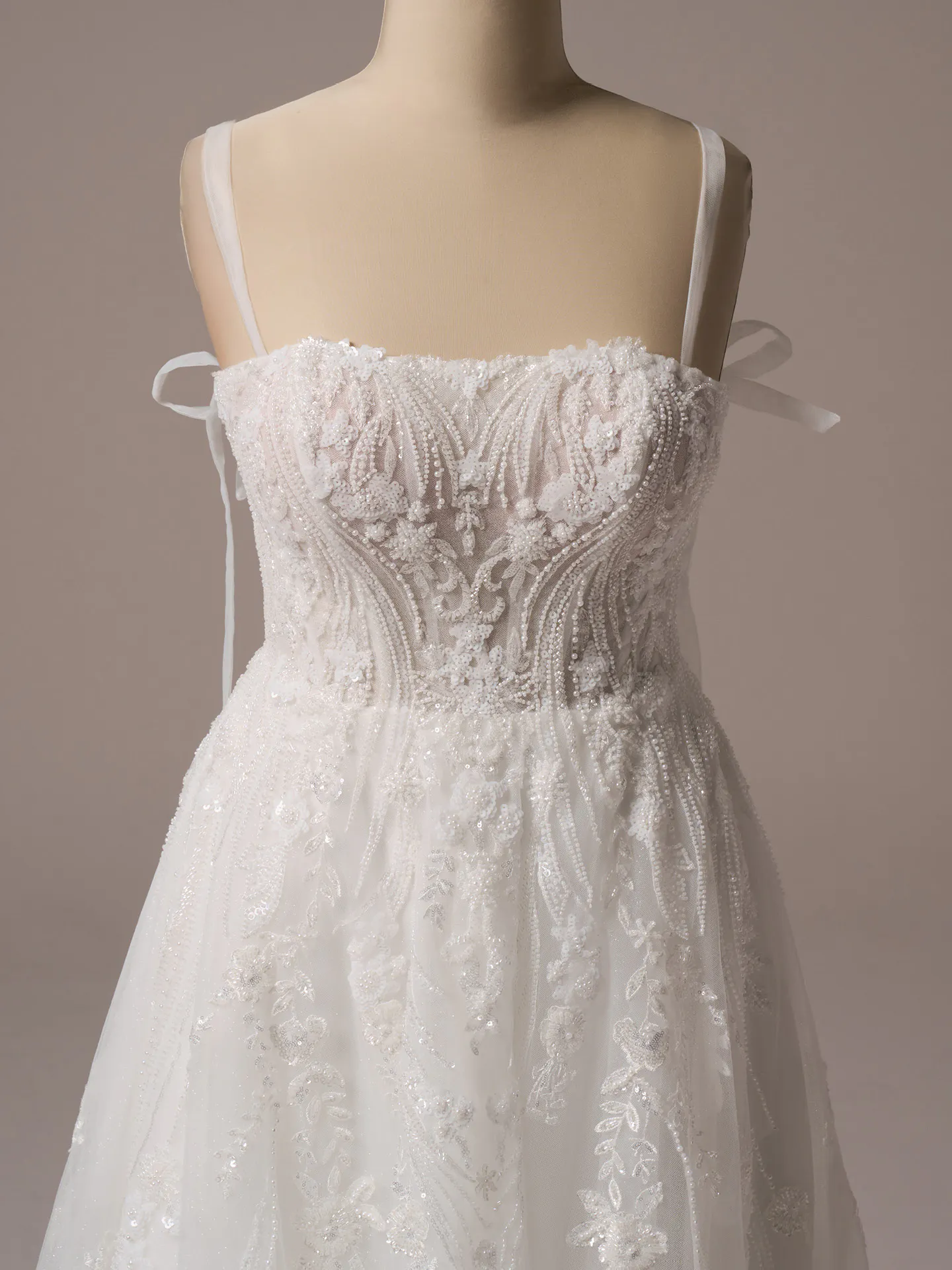 Rebecca Ingram Angie front view beaded A-line wedding gown with floral details.