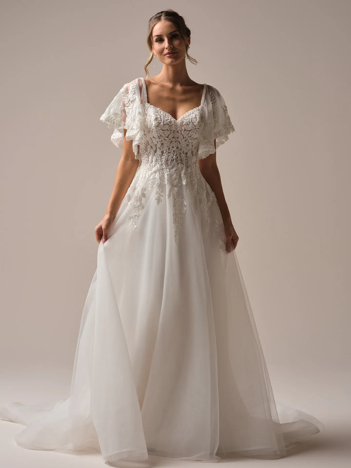 Rebecca Ingram Carmen front view wedding gown with lace bodice and flutter sleeves.