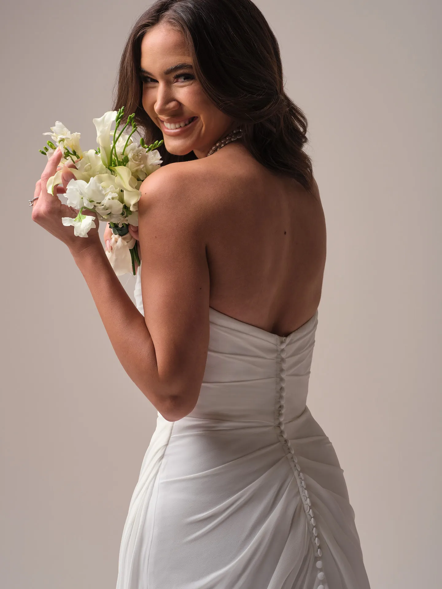 Rebecca Ingram Francesca back view with button detail, holding flowers in hand.