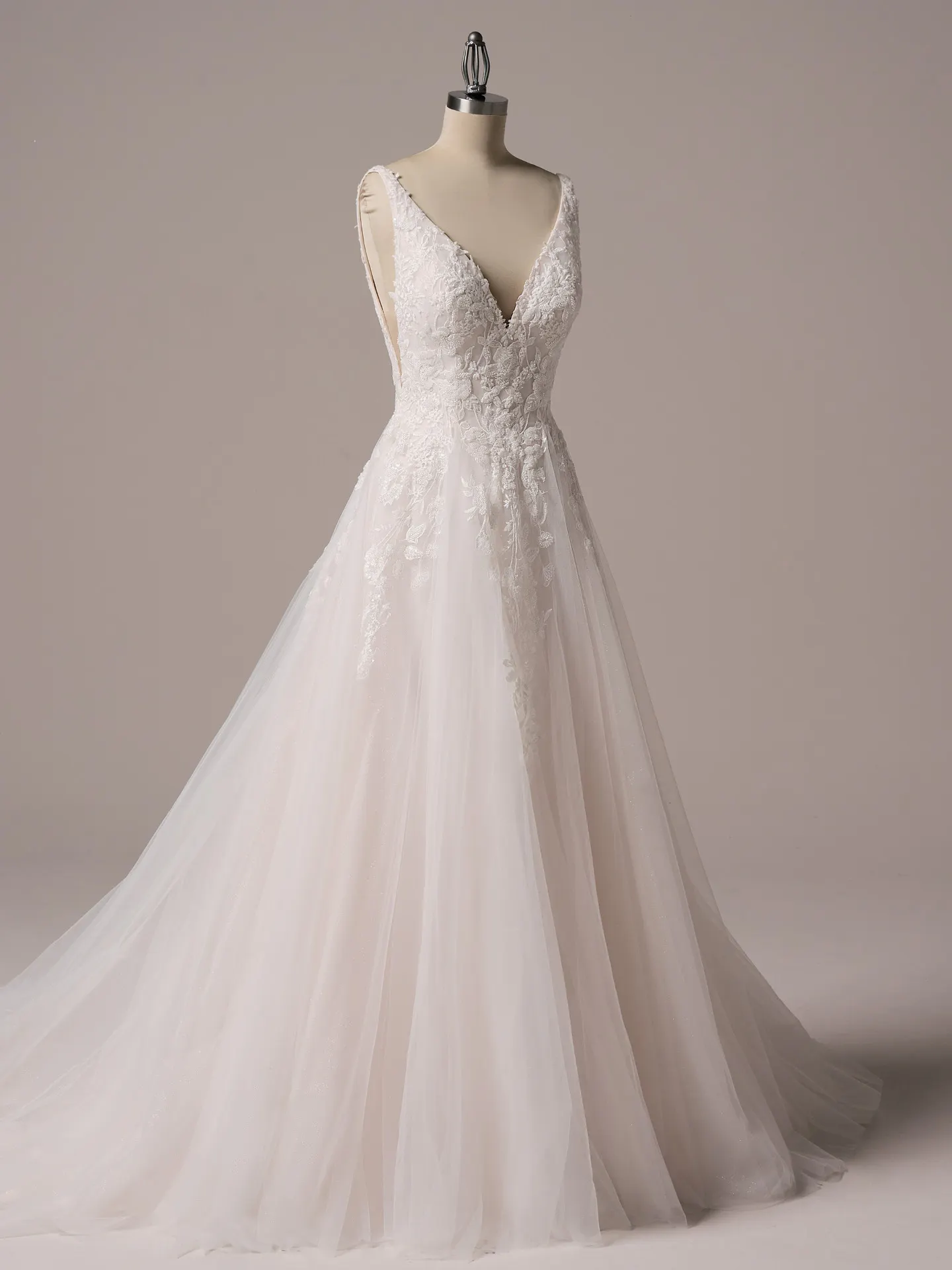 Rebecca Ingram Honor A-line gown on mannequin with beaded V-neck, side view.