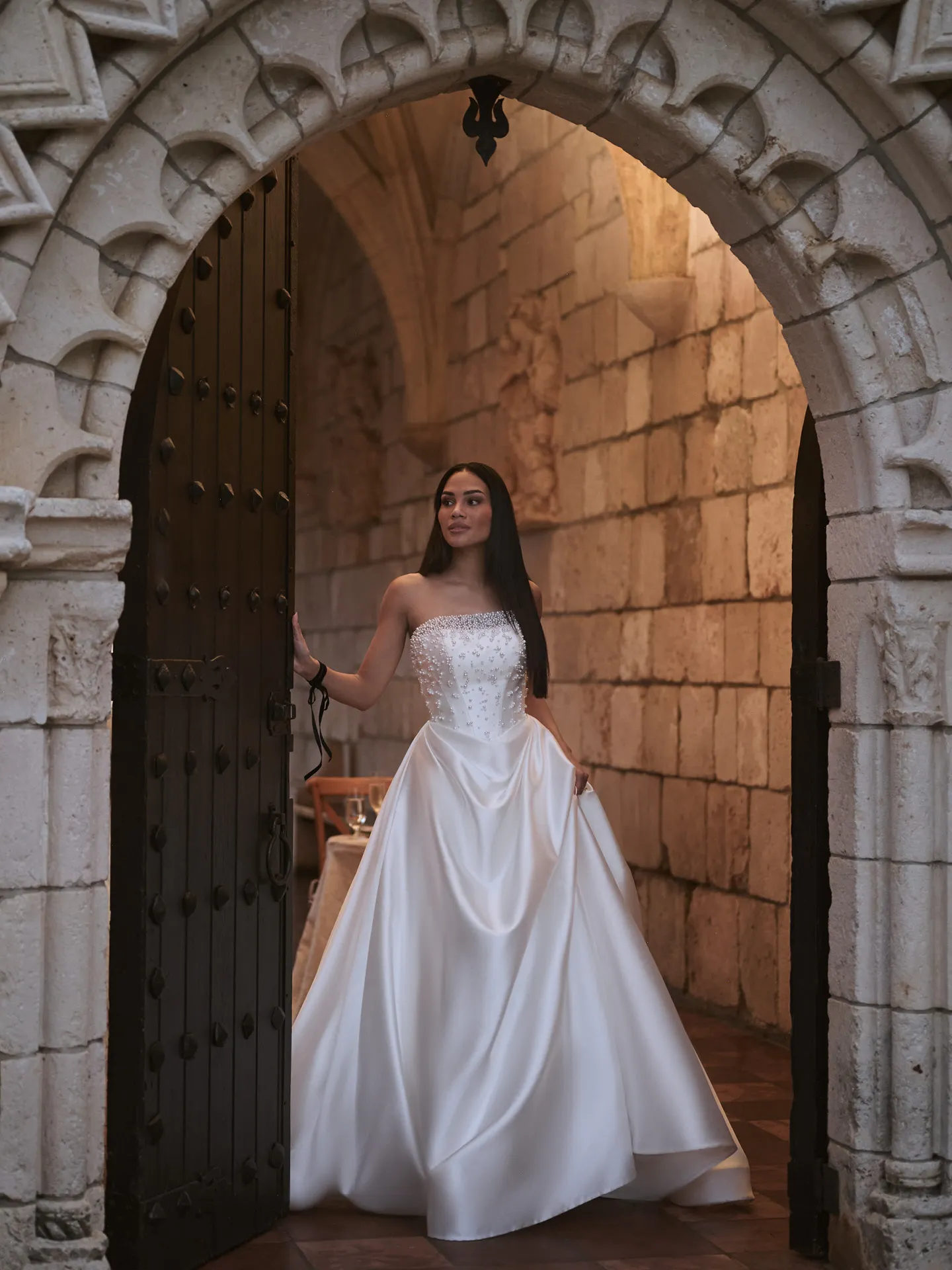Sottero and Midgley Tenille front view satin A-line dress in stone archway.