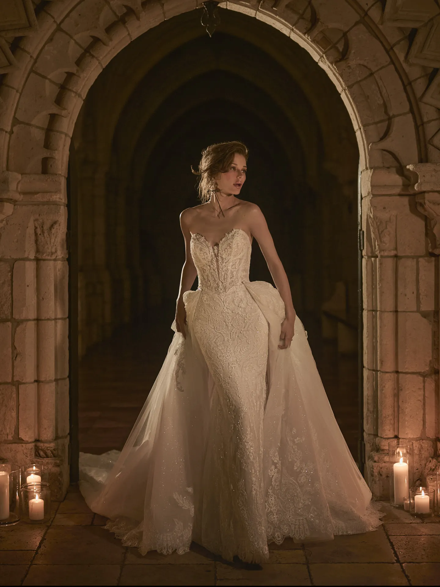 Sottero and Midgley Zareen front view, lace mermaid dress in arched candlelit corridor