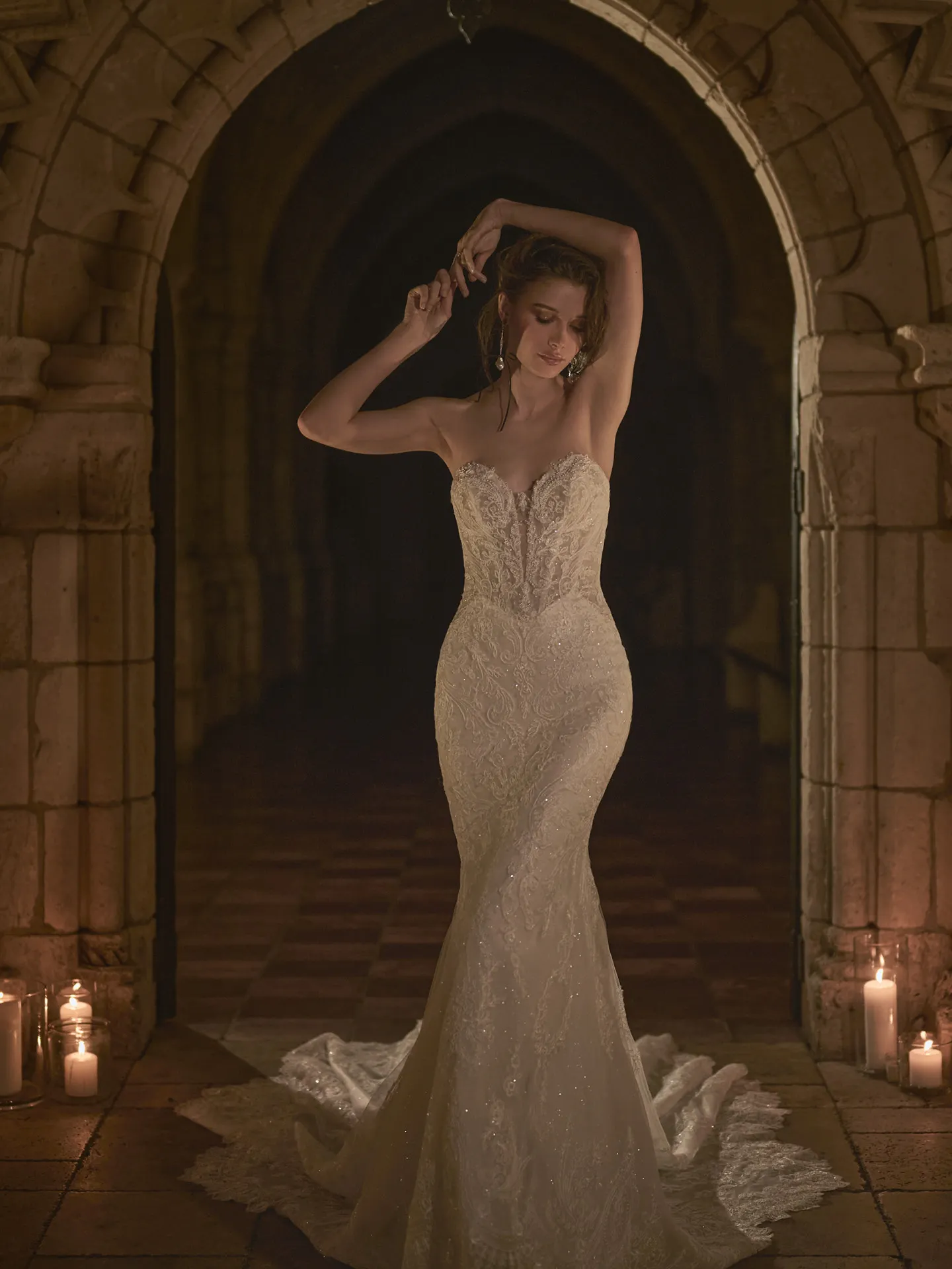Sottero and Midgley Zareen front view, illusion lace mermaid dress in candlelit stone archway.