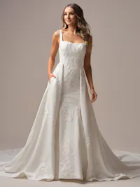Clean satin train with unembellished lace motifs and pockets