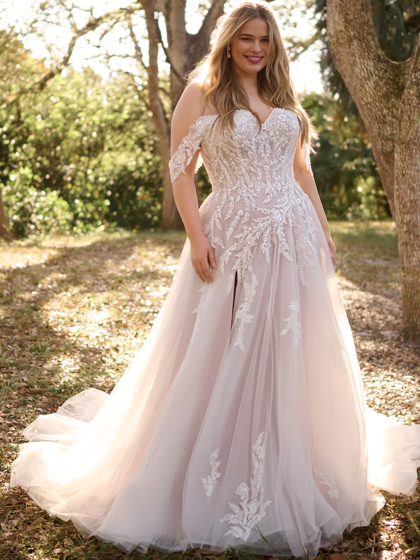 Rebecca Ingram Victoria front view with off-shoulder beaded lace in a garden setting