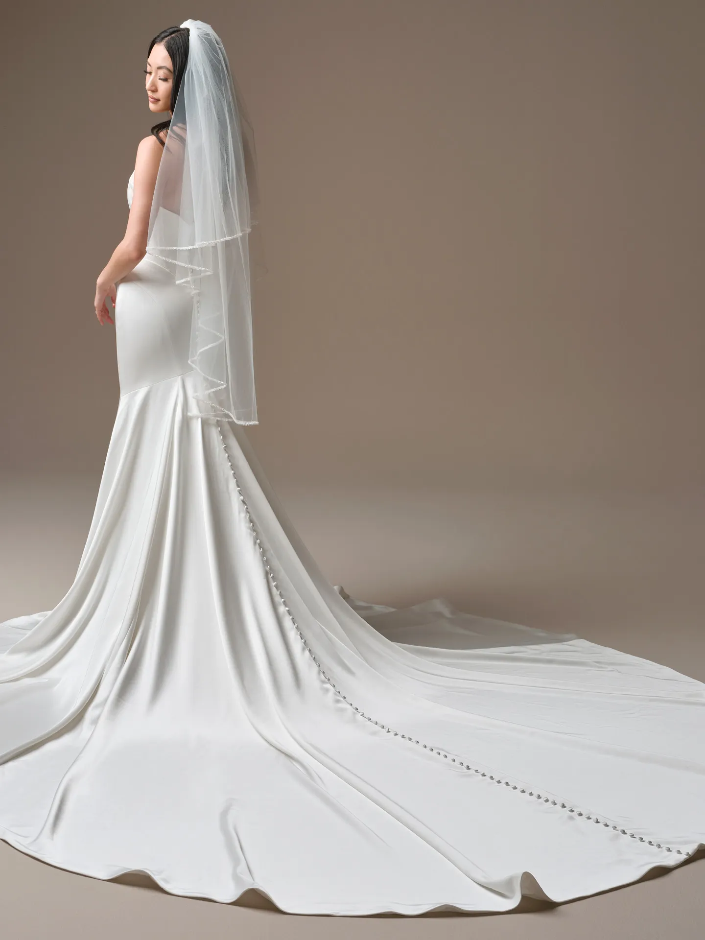 Maggie Sottero Sinclaire sheath dress, back view with veil and button detail.