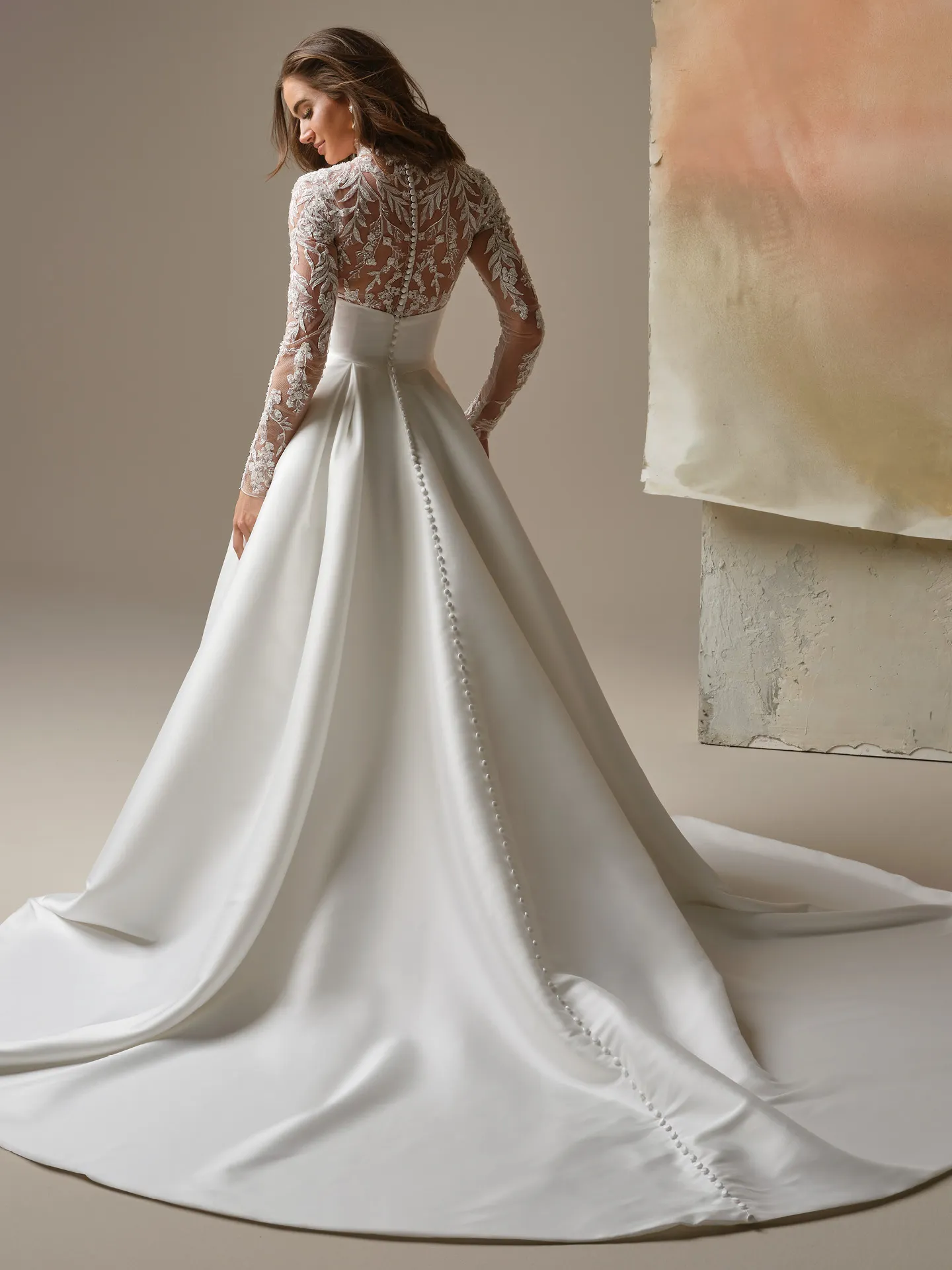 Maggie Sottero Trinity, back view A-line wedding dress with lace sleeves and button detail.