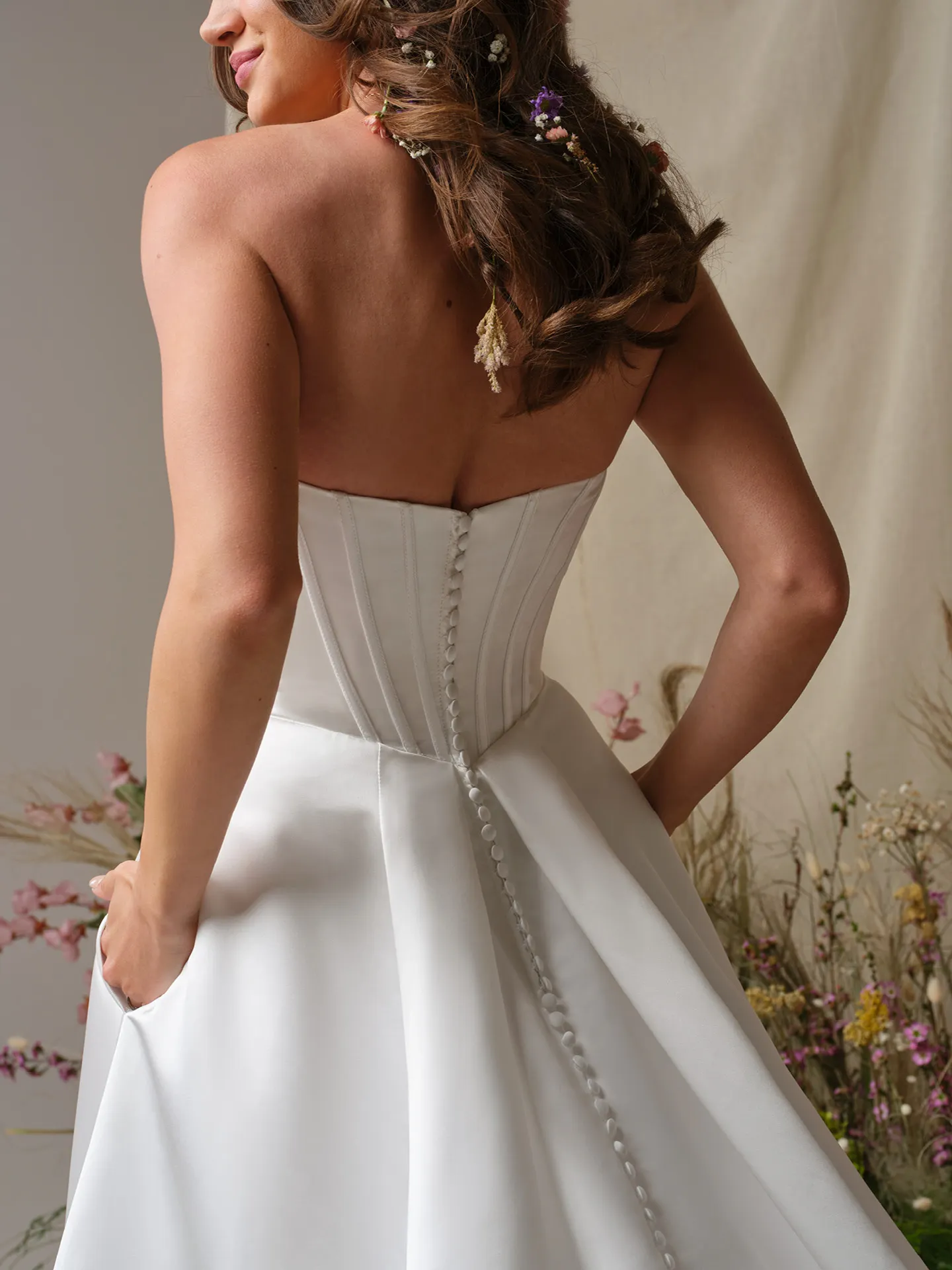 Rebecca Ingram Alexia, back view satin A-line gown with basque waist and buttons.