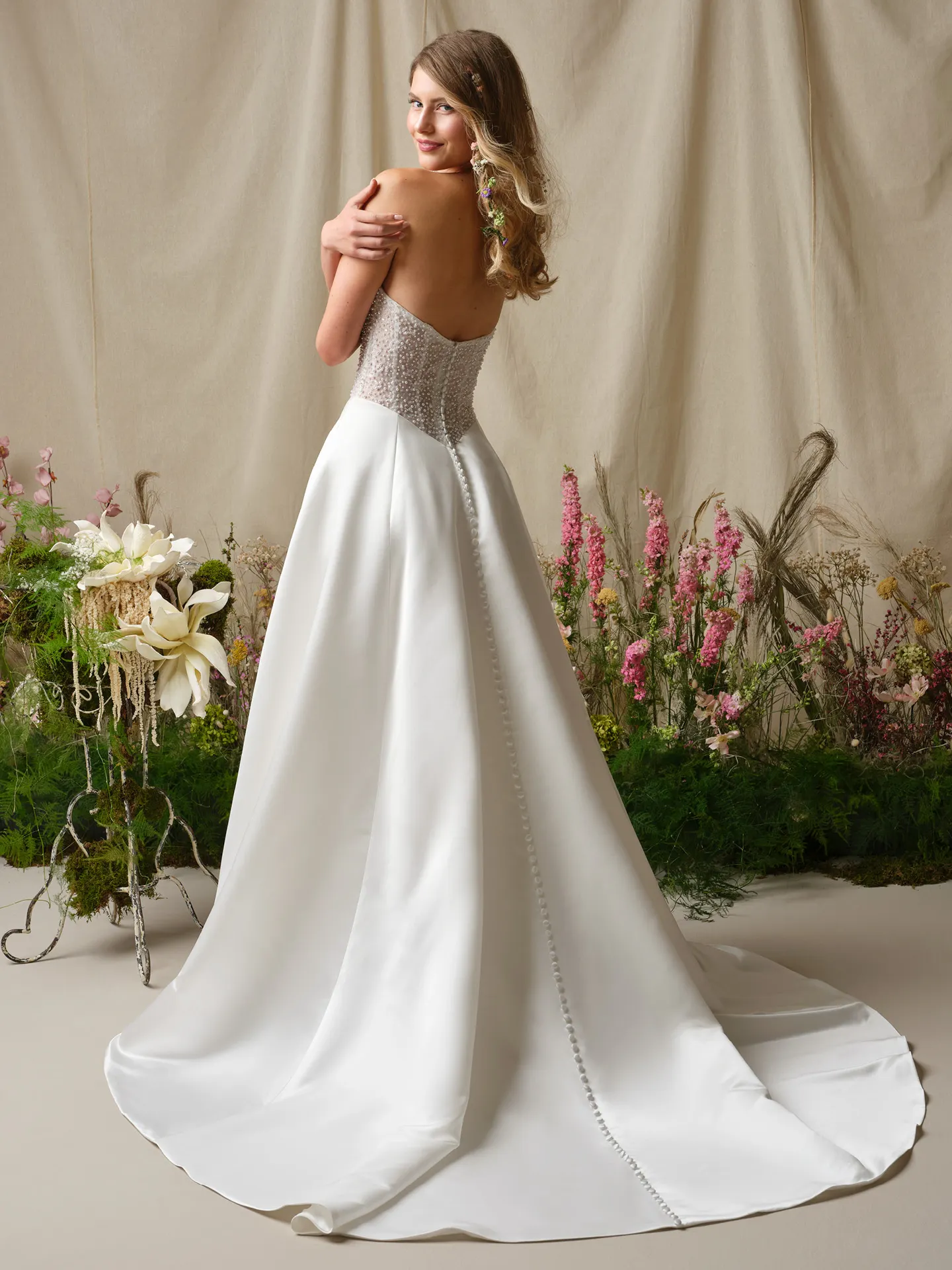 Rebecca Ingram Marty back view A-line, pearl-accented wedding dress with train, floral setting