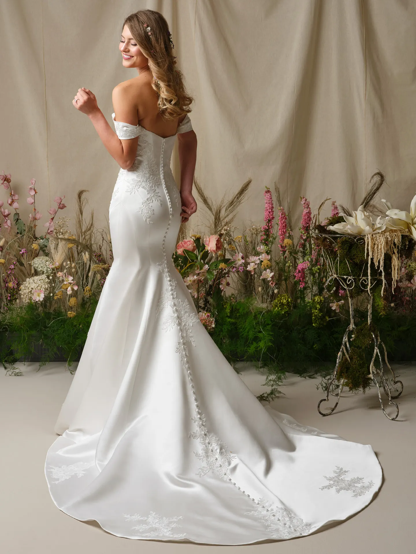 Rebecca Ingram Miley back view, off-the-shoulder, lace fit-and-flare dress, floral background