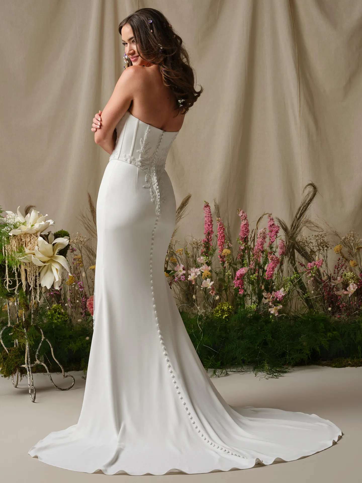 Rebecca Ingram Terry back view sheath wedding dress with button detail and floral background