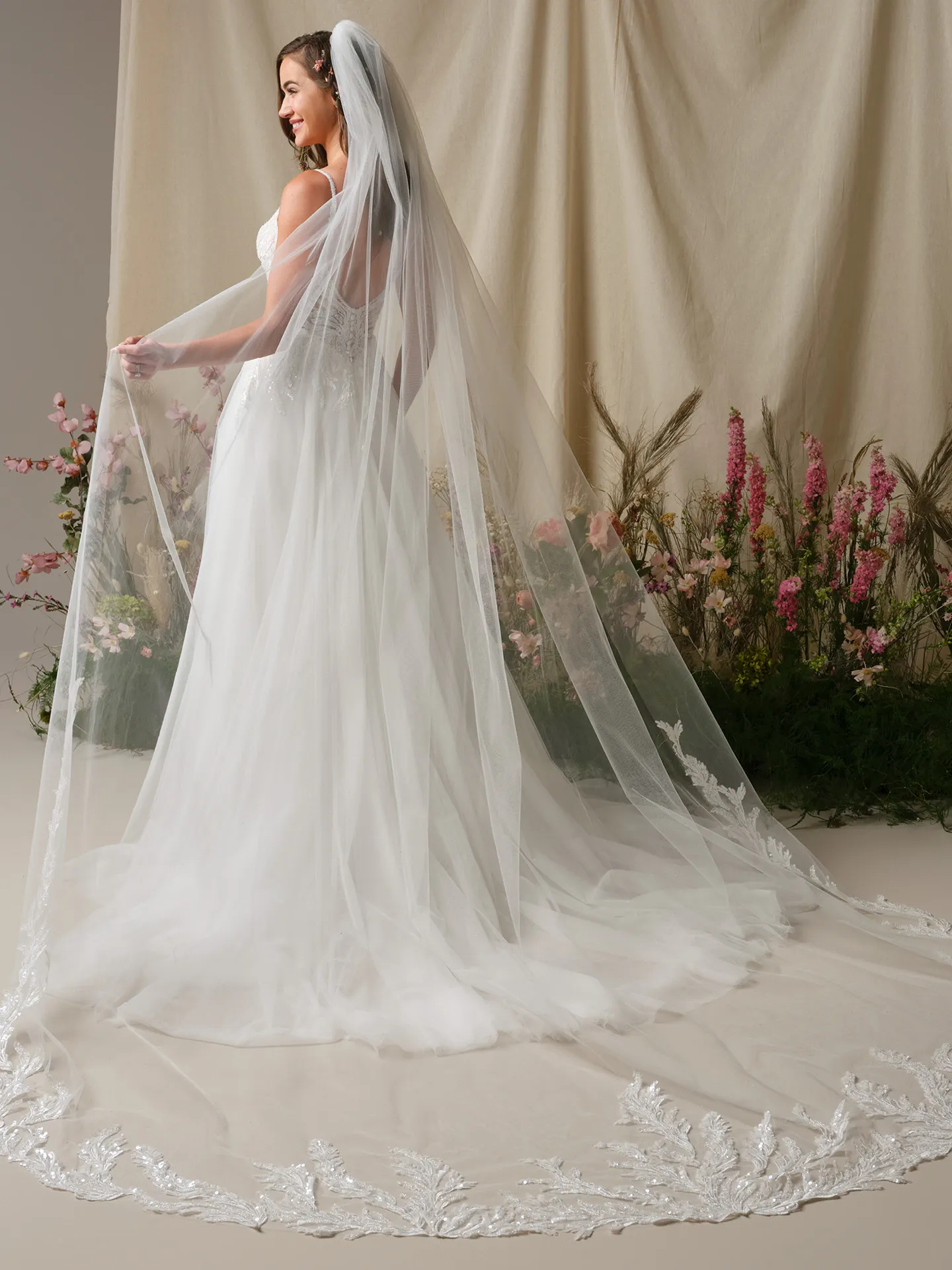 Rebecca Ingram Valarie back view lace A-line wedding dress with veil and floral backdrop