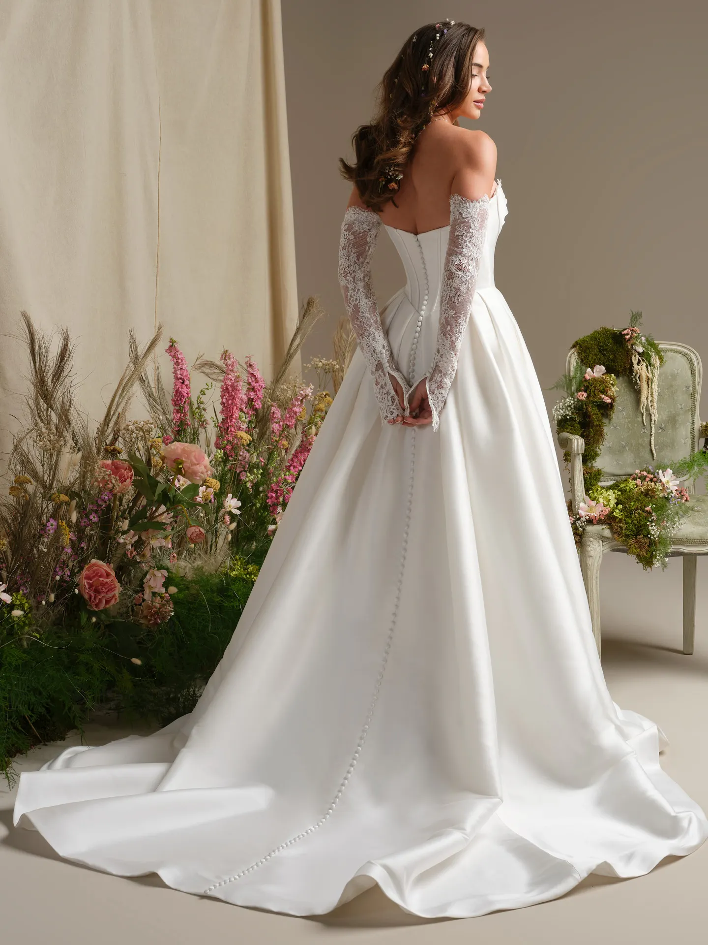 Rebecca Ingram Zorina back view with lace trim and side slit ballgown in floral setting