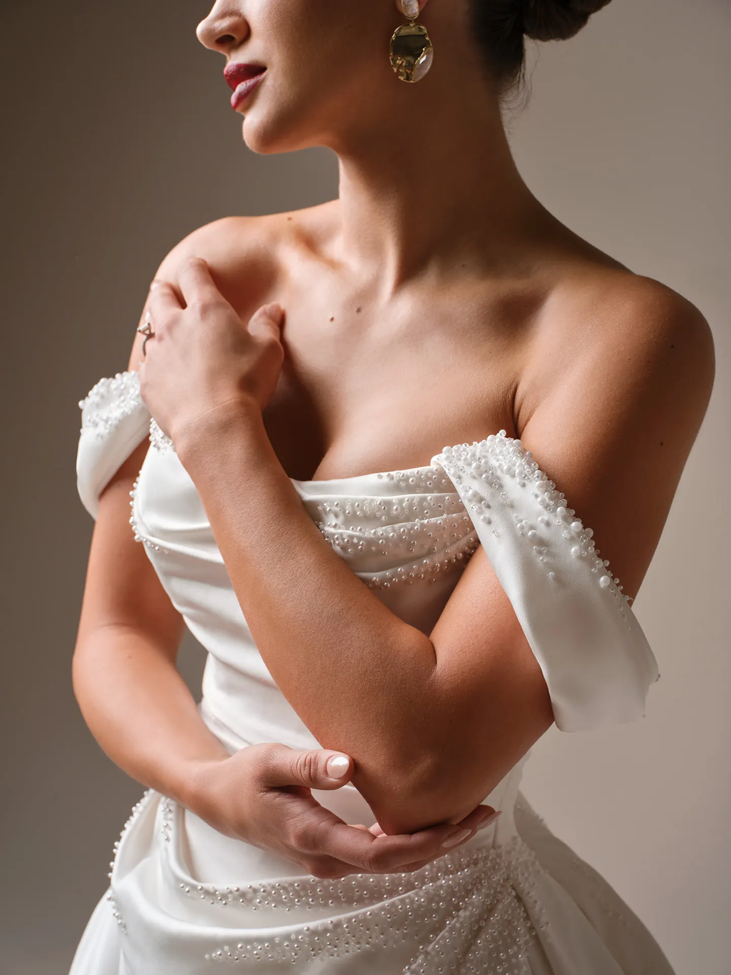 Sottero and Midgley Kincaid beaded satin ballgown close-up, focus on beaded off-shoulder design.