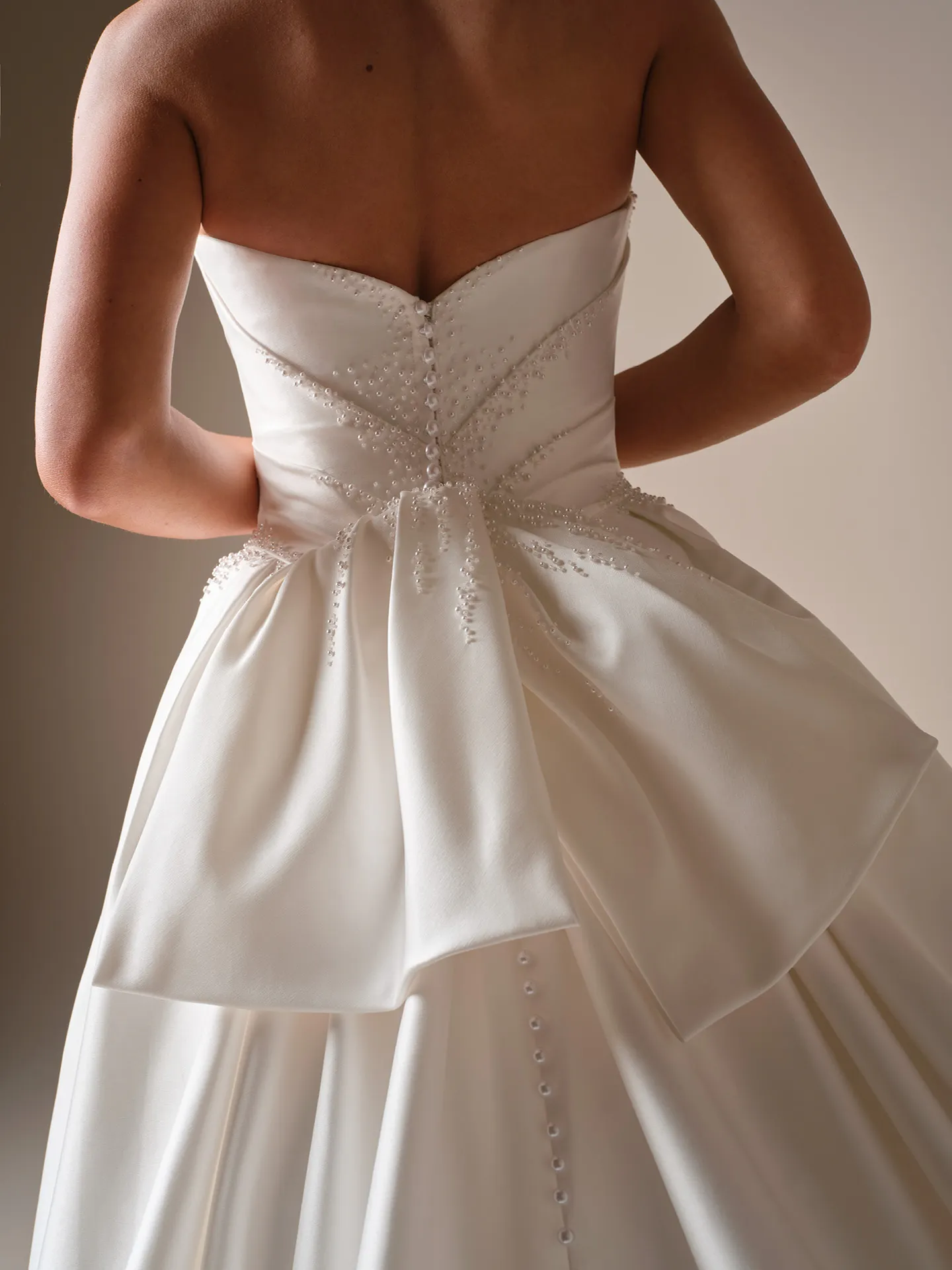 Sottero and Midgley Kincaid, back view beaded satin ballgown with bow detail.