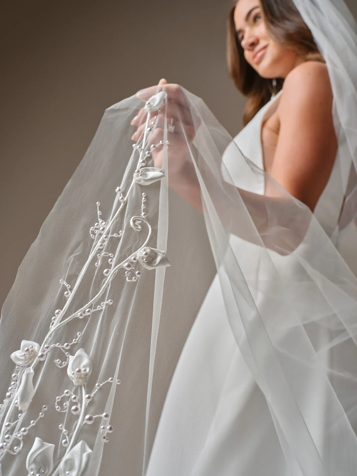 Maggie Sottero Lawrence veil detail with floral embroidery, side view of satin A-Line dress.