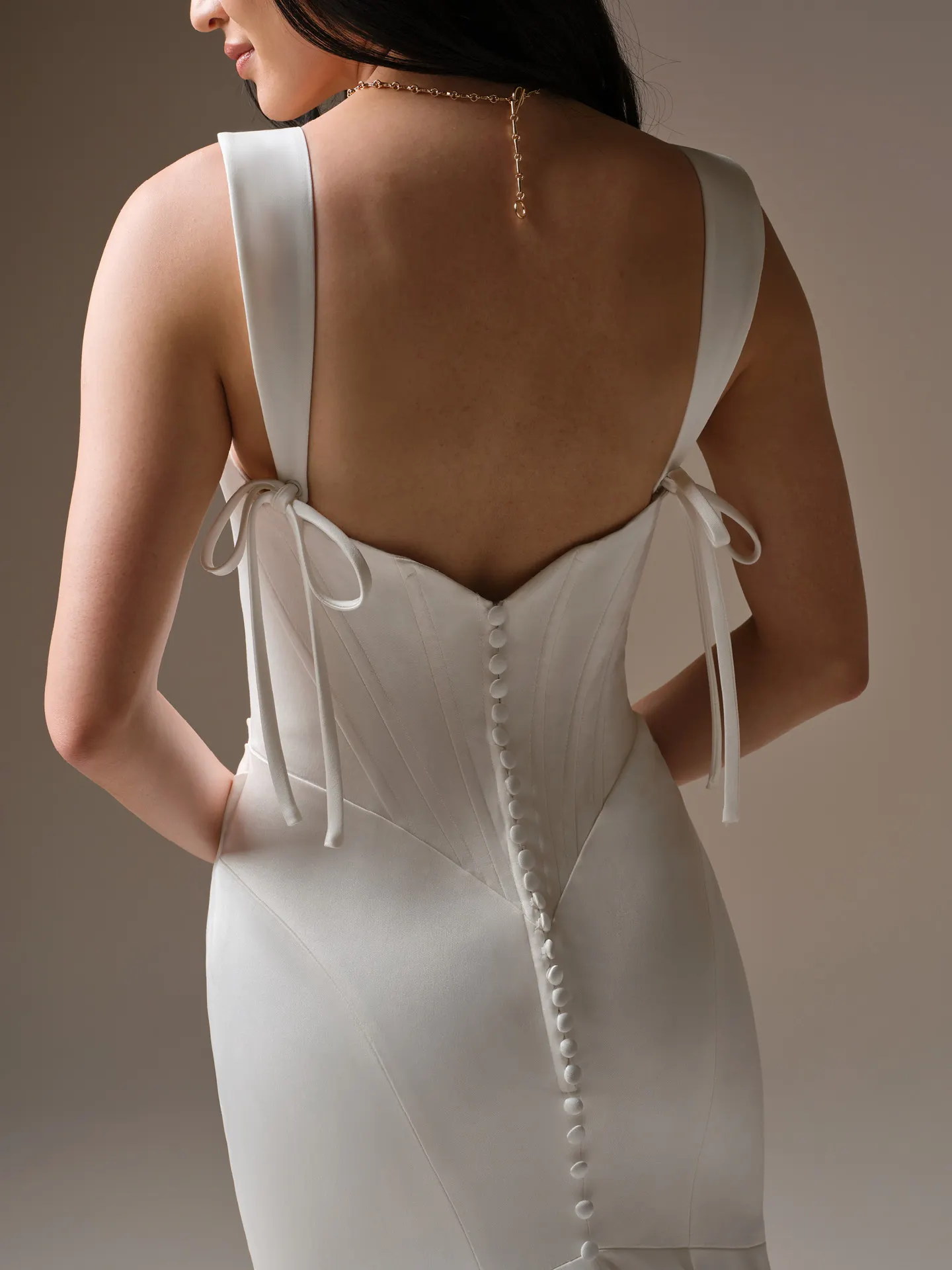Maggie Sottero Sinclaire, back view with bow-tied straps and button detail.
