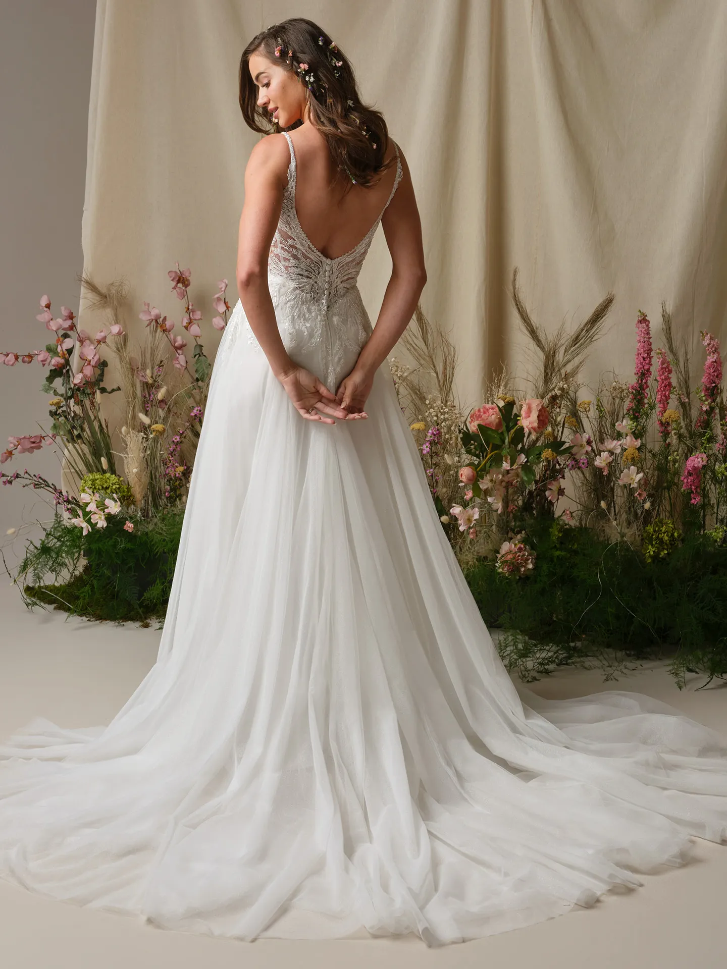 Rebecca Ingram Valarie back view, lace A-line wedding dress with floral background