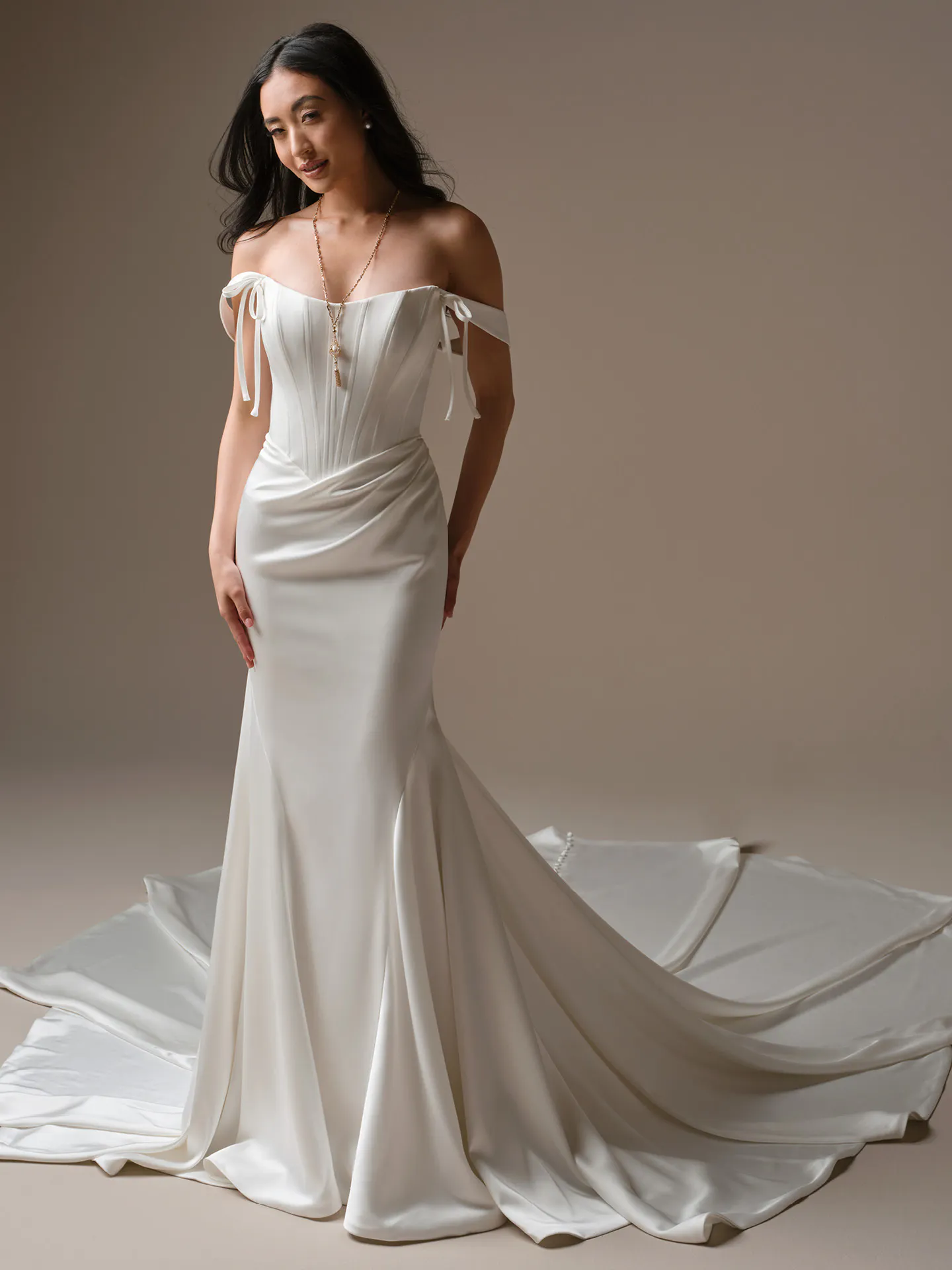 Maggie Sottero Sinclaire sheath wedding dress, front view with off-shoulder sleeves and train.