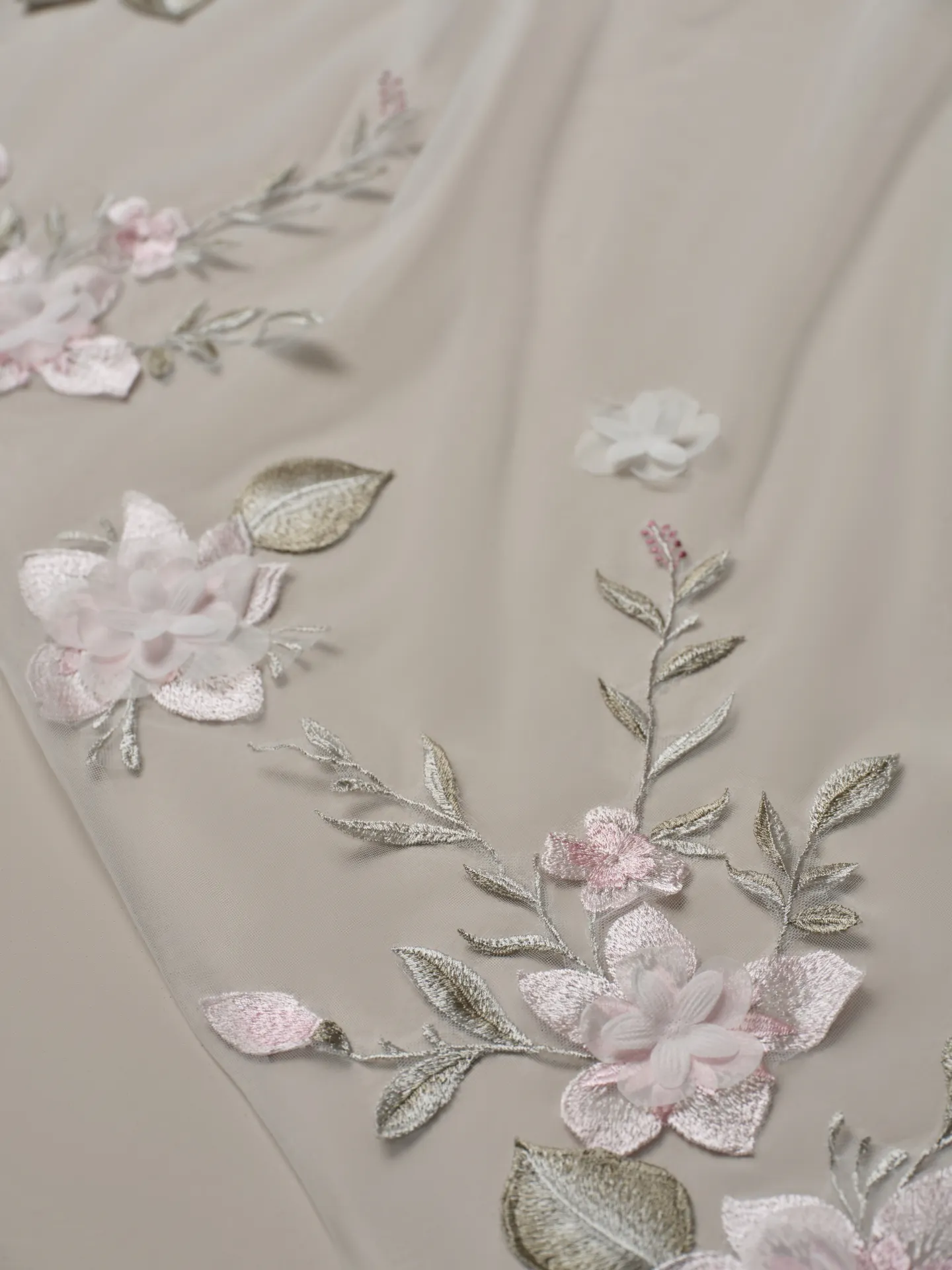Rebecca Ingram veil close-up with lace and pink floral motifs.