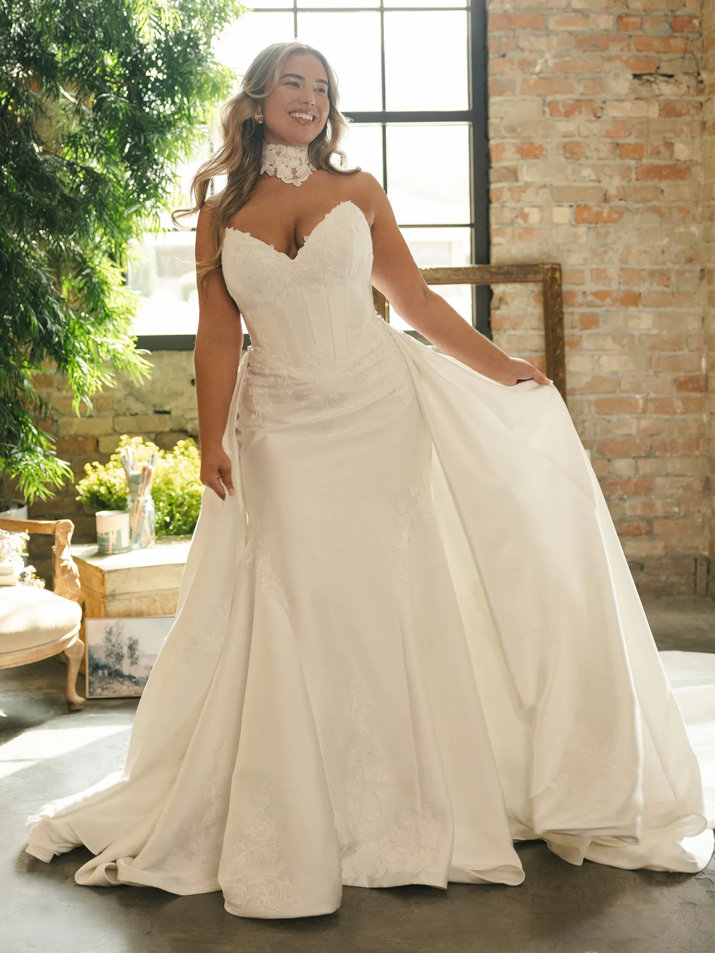 Rebecca Ingram Serafina, front view satin ballgown with lace detail in rustic interior.