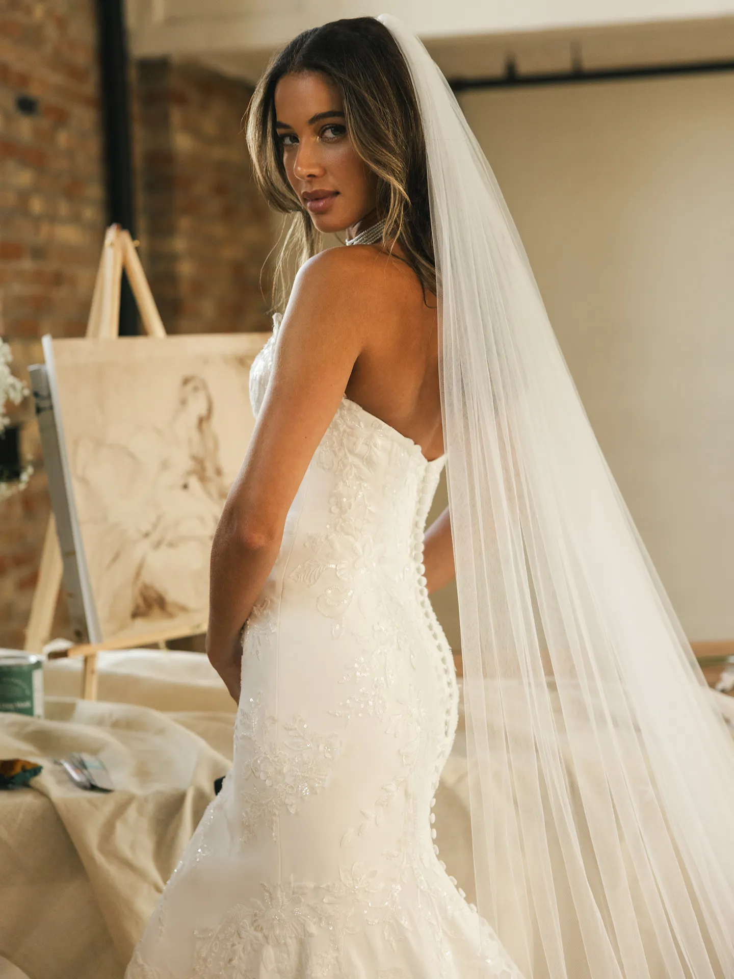 Maggie Sottero Thera, side view fit-and-flare lace wedding dress with long veil.