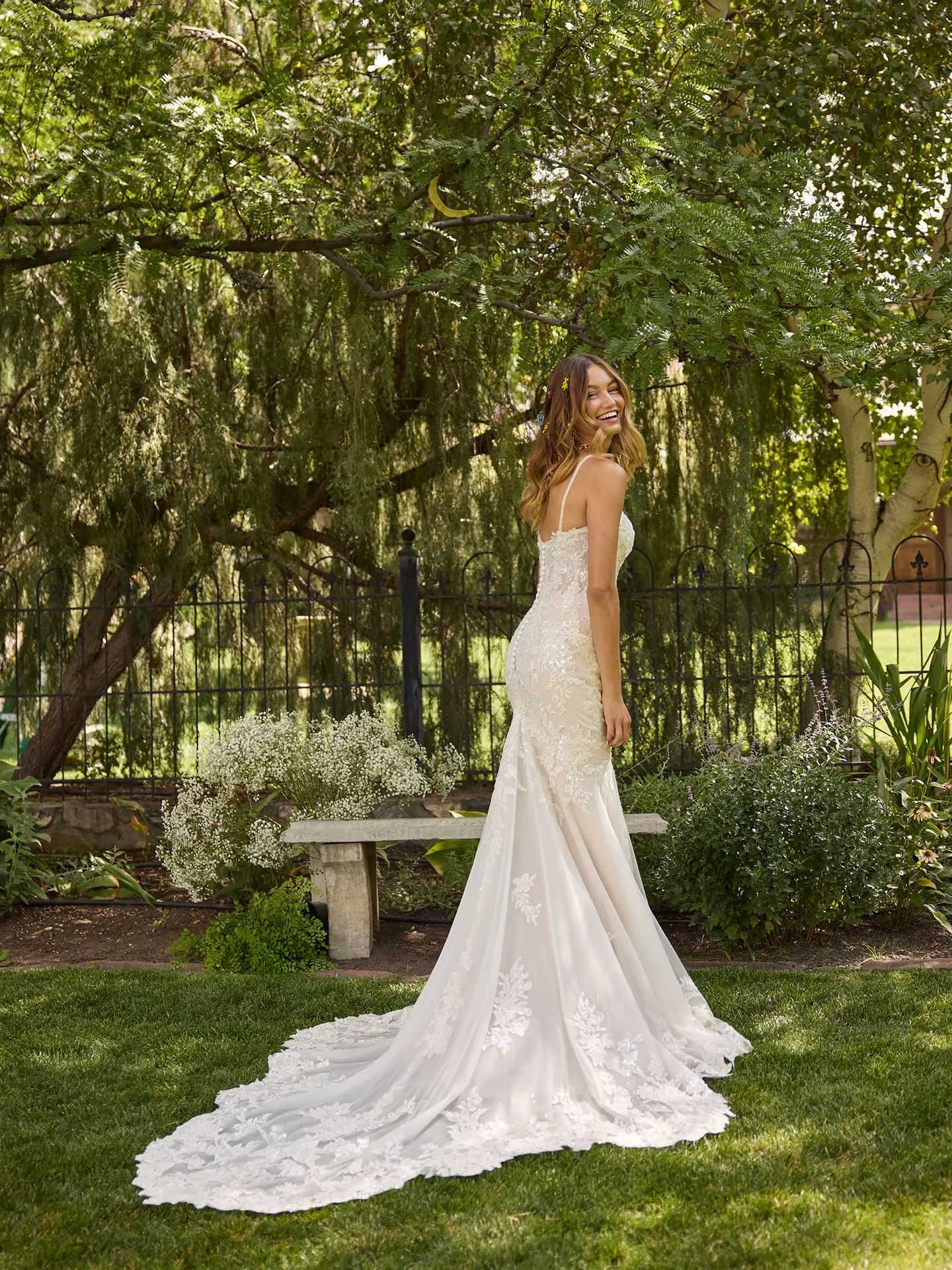 Rebecca Ingram Eden lace fit-and-flare wedding dress, back view in garden.