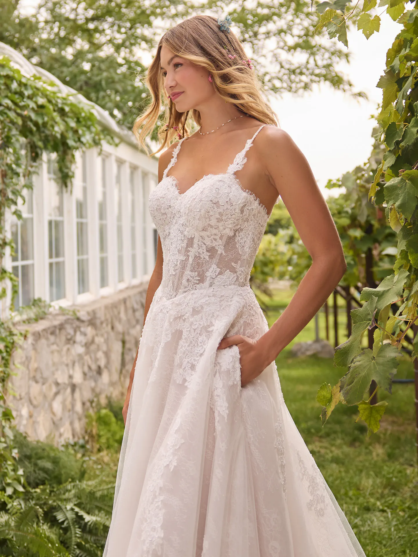 Rebecca Ingram Esmeralda A-Line front view, sweetheart neckline, lace detail, garden background