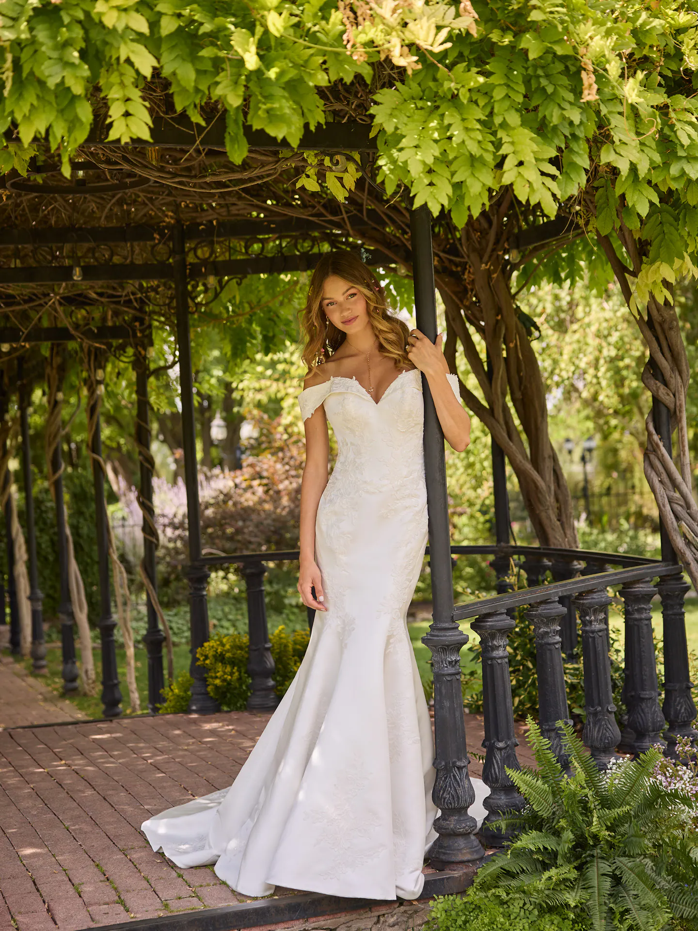 Rebecca Ingram Miley front view in garden, off-the-shoulder fit-and-flare wedding dress