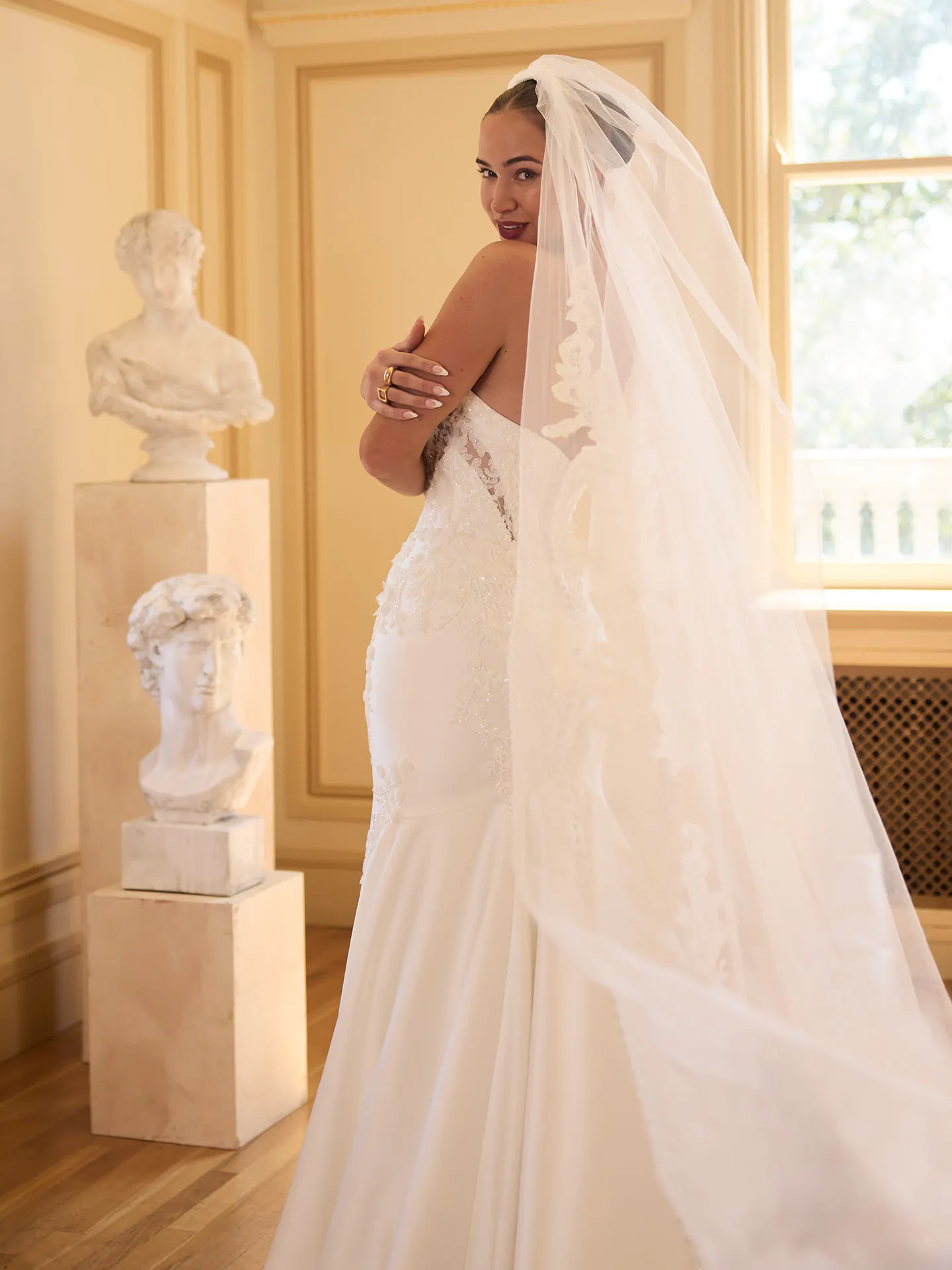 Maggie Sottero Burke, side view, beaded lace fit-and-flare wedding dress with veil.