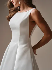Maggie Sottero Lawrence, side view shows satin A-line gown with bateau neck.