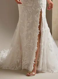 Sottero and Midgley West, front view lace fit-and-flare wedding dress with slit detail.